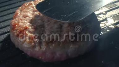 特写的大牛肉切块是烤的，厨师用铁铲把切块压到烤架上。 慢速视频